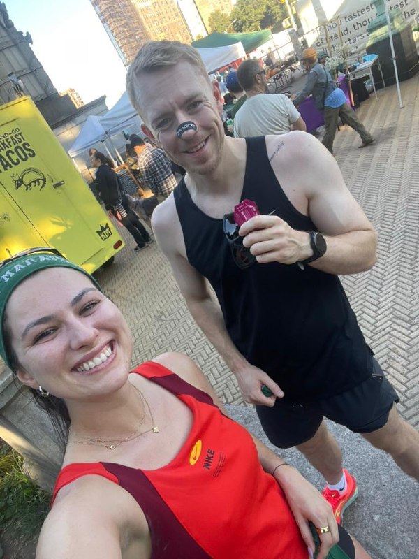 Post-run selfie at a street market, race gear on