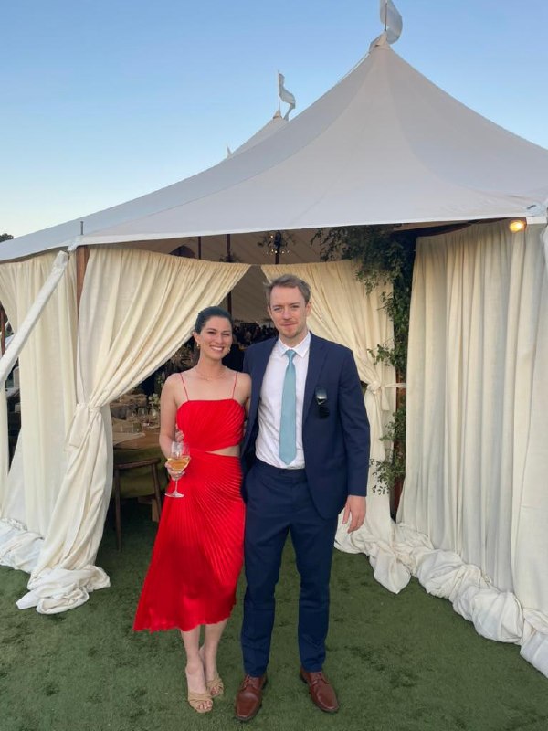 Dressed up outside a marquee tent at a summer wedding